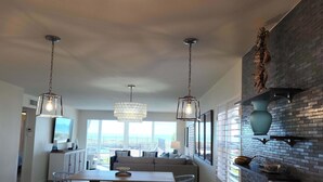 A modern kitchen with a central island, pendant lighting, and a view to the outside. - Whitney Beach 321 2brm beachfront (Longboat Key)