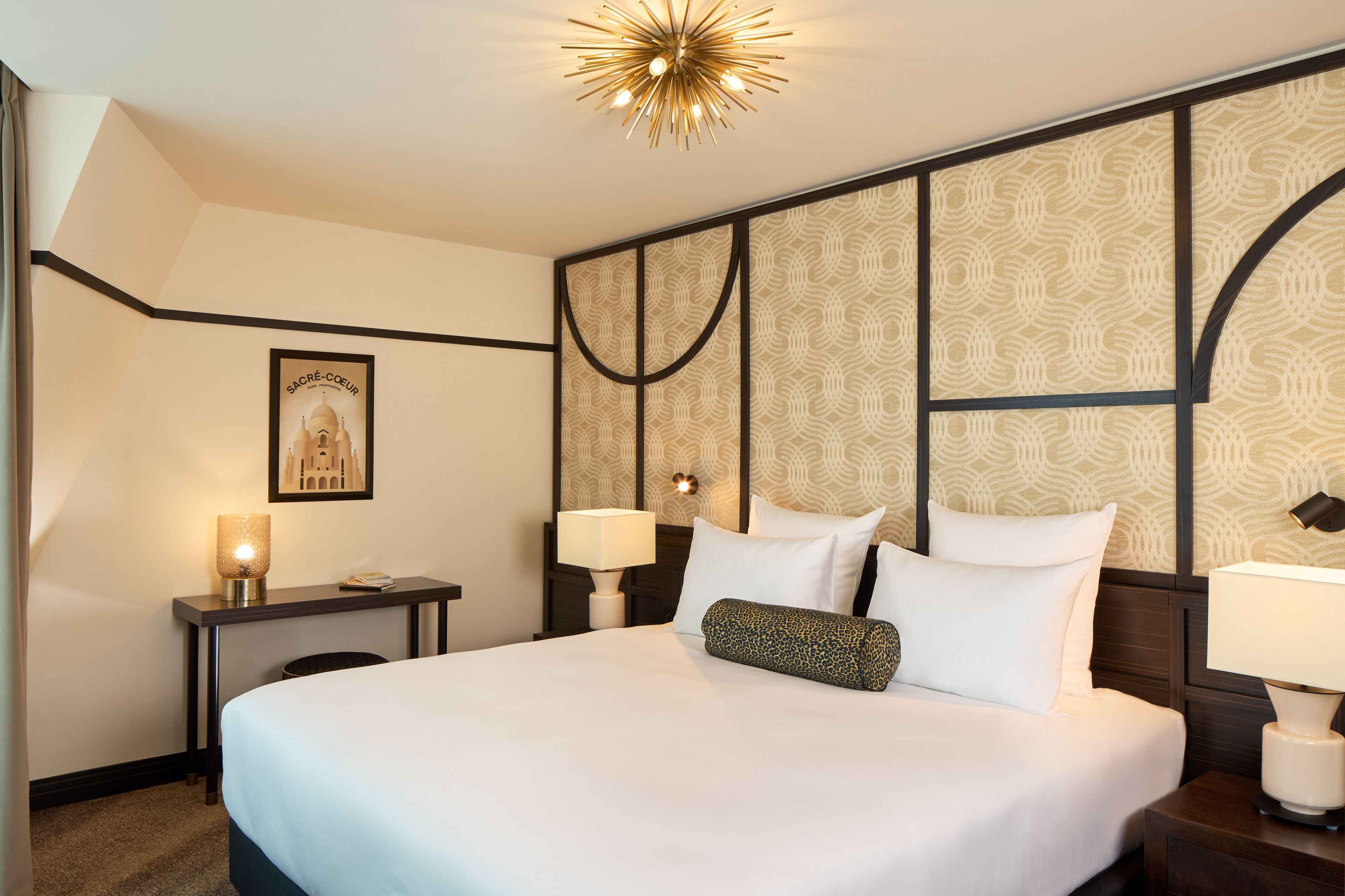 Ein Hotelzimmer mit einem großen Bett, zwei Nachttischen, einer Wandleuchte und einer Deckenlampe.
