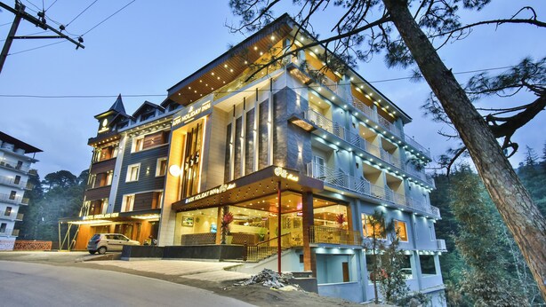 Ein mehrgeschossiges Hotel mit moderner Fassade, Balkonen und einem gut beleuchteten Eingang.
