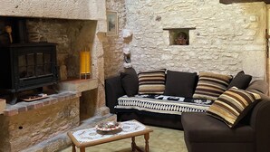 Ein Zimmer mit Stehwänden, einem Kamin, einer Couch und einem kleinen Tisch.