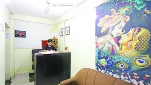 A room with a desk, a chair, a wall clock, and a framed picture. - Hotel Raaso inn Nawada Metro By Arrow  (New Delhi)