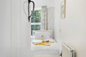 A bedroom with a bed, a teddy bear, and a breakfast setup.