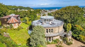 A large estate with a round tower, a separate house with a conical roof, and a well-maintained lawn.