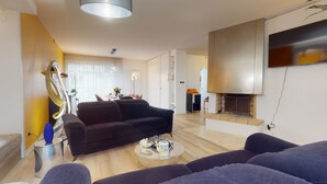 A modern living room with a sofa, a coffee table, and a fireplace.