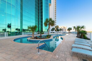 A swimming pool area with a modern building in the background. - Turquoise Place 1108 D (Orange Beach)
