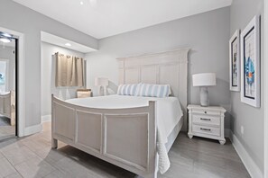A bedroom with a bed, bedside table, lamp, and artwork on the wall. - Turquoise Place 1108 D (Orange Beach)