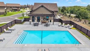 Un edificio residenziale con piscina, area relax all'aperto e giardino recintato.