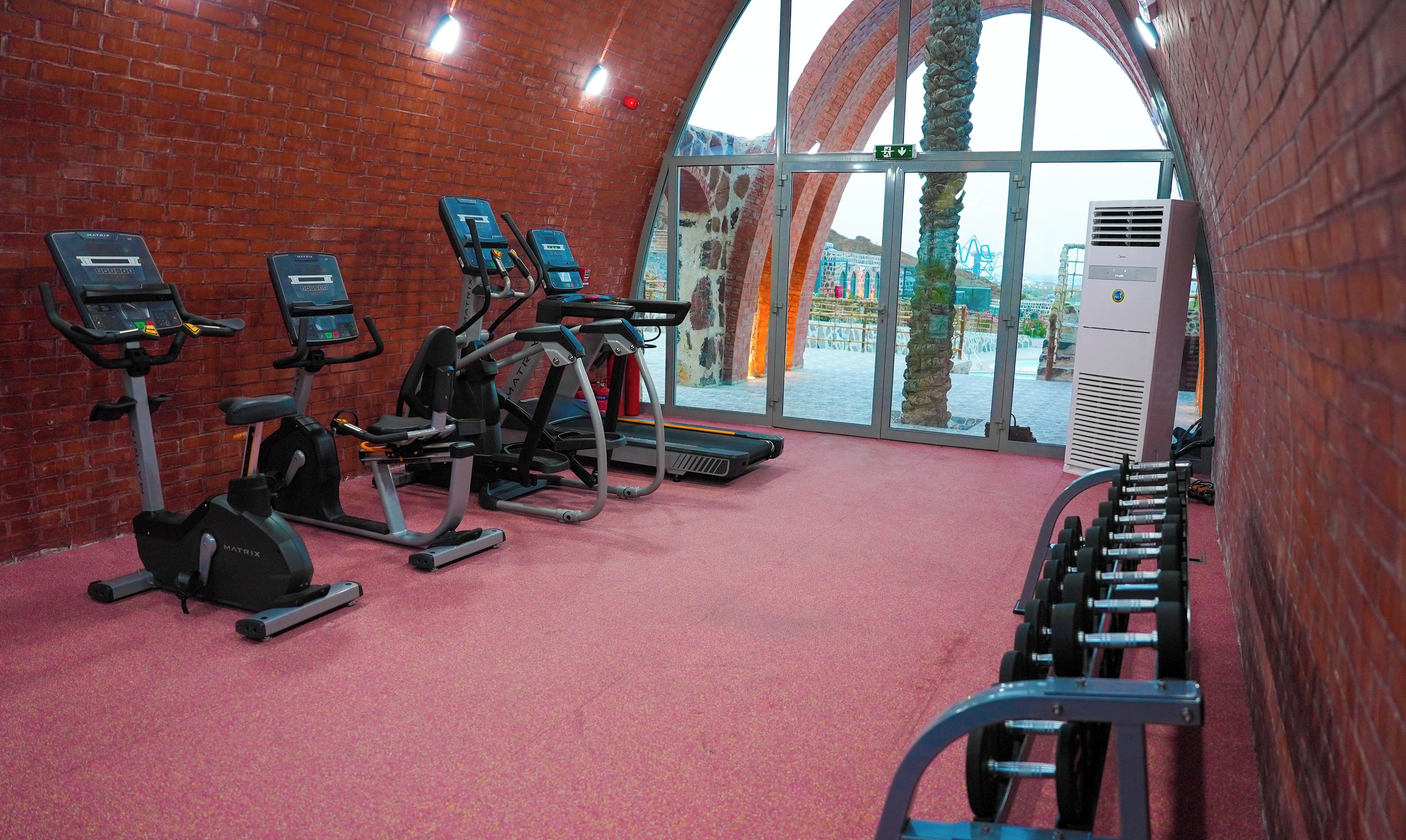 Academia com esteiras, bicicletas ergométricas e área de musculação.