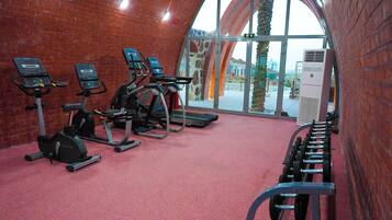 Academia com esteiras, bicicletas ergométricas e área de musculação.