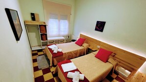 A room with two beds, a wooden headboard, a checkered floor, and a window with blinds. - Girona Centre 7pax Aparcamiento Coche,moto,bicicleta (Girona)