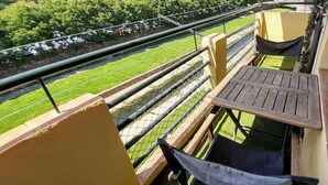 A balcony with a view of a green lawn and a fence. - Girona Centre 7pax Aparcamiento Coche,moto,bicicleta (Girona)