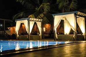 Una piscina al aire libre, sillones reclinables de piscina