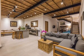 Relax in a spacious living area with a sofa and coffee table, featuring a kitchen island and dining table with benches.