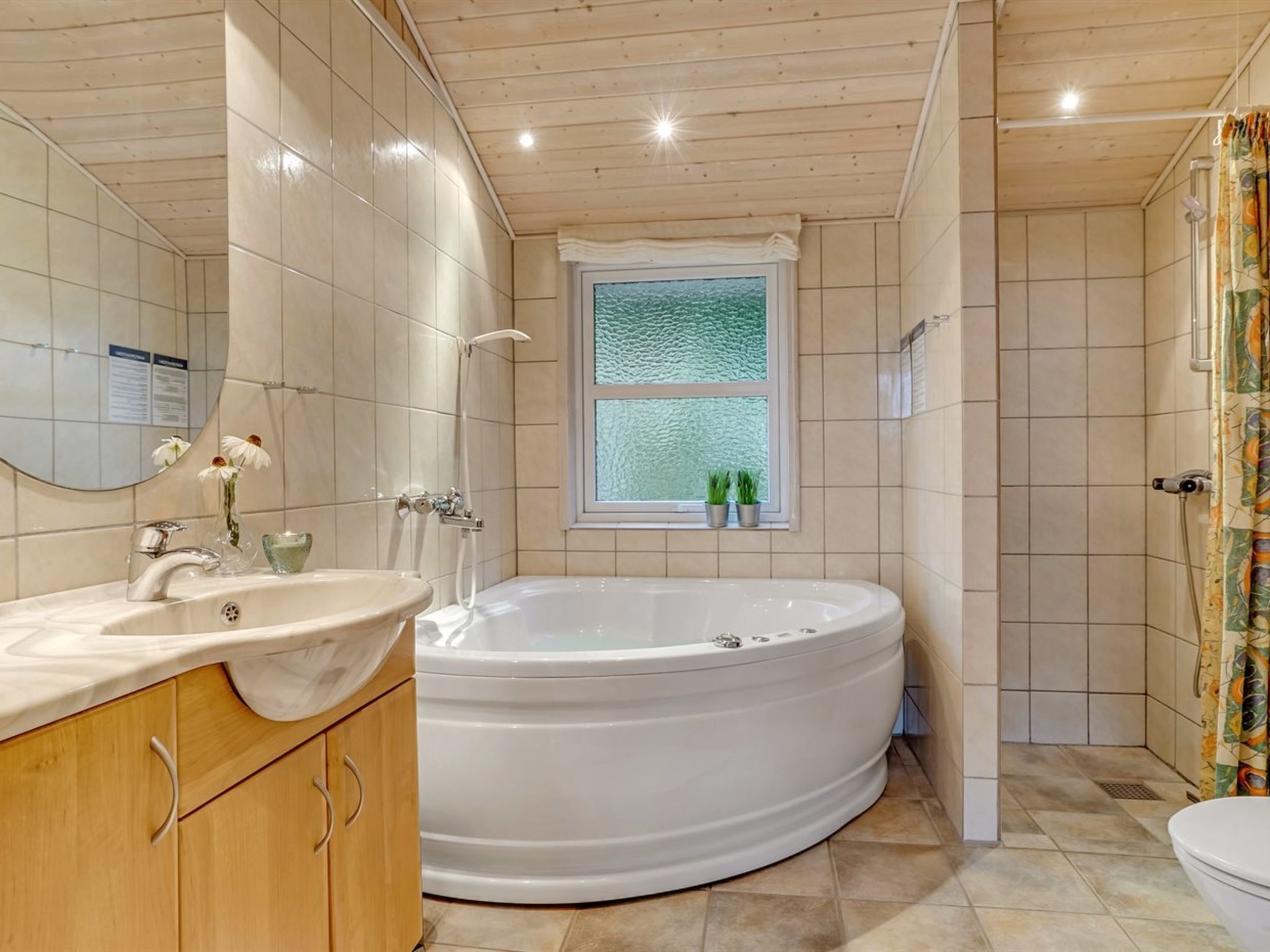 Un baño moderno con una bañera independiente, un tocador con lavamanos y una zona de ducha.