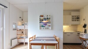 A compact kitchen with white cabinets, a dining table with chairs, and a small kitchenette area. - "Tinke" - 150m from the sea by Interhome (Løkken)