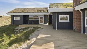 Una casa moderna con techo plano y terraza de madera.