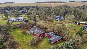 Una zona residencial con varias casas, un campo abierto y una masa de agua al fondo.