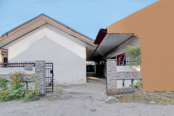 A gated entrance to a building with a brick pillar and a metal gate. - Hotel O Teguh Homestay Syariah (Pekanbaru)