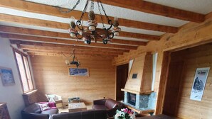 Un interno in legno con un grande tavolo da pranzo, sedie, un divano e un camino.
