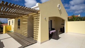 A covered outdoor area with a pergola, a table with chairs, and a small seating area. - Prikichi C2 Relax & Dive Resort Bonaire Village (Kralendijk)