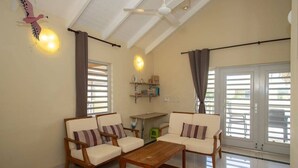 A living room with two sofas, a wooden coffee table, and a ceiling fan.