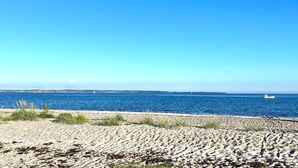A beach with a clear sky and calm sea.