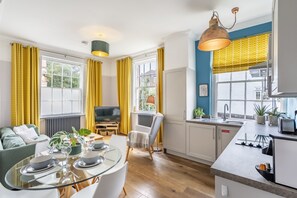 Un appartement moderne comprenant un coin repas, une cuisine et un espace de vie.