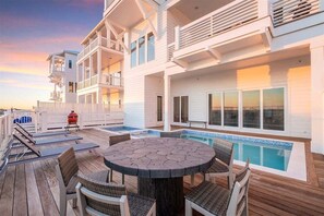 A deck with a pool, outdoor seating, and a barbecue grill. - Explore "Coastal View" - New Custom Beach Home! (Inlet Beach)
