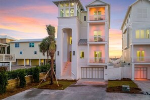 A multi-story residential building with a central staircase, a covered porch, and a garage. - Explore "Coastal View" - New Custom Beach Home! (Inlet Beach)
