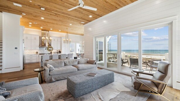 A spacious living room with a large gray sofa, a leather armchair, and a wooden ceiling. - Ultimate 8-Bedroom Getaway for Families & Groups (Inlet Beach)