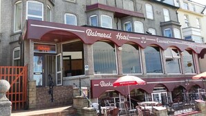 A Balmoral Hotel with a red awning, outdoor seating area, and a sign indicating 'Entrance'. - The Balmoral Hotel (Blackpool)