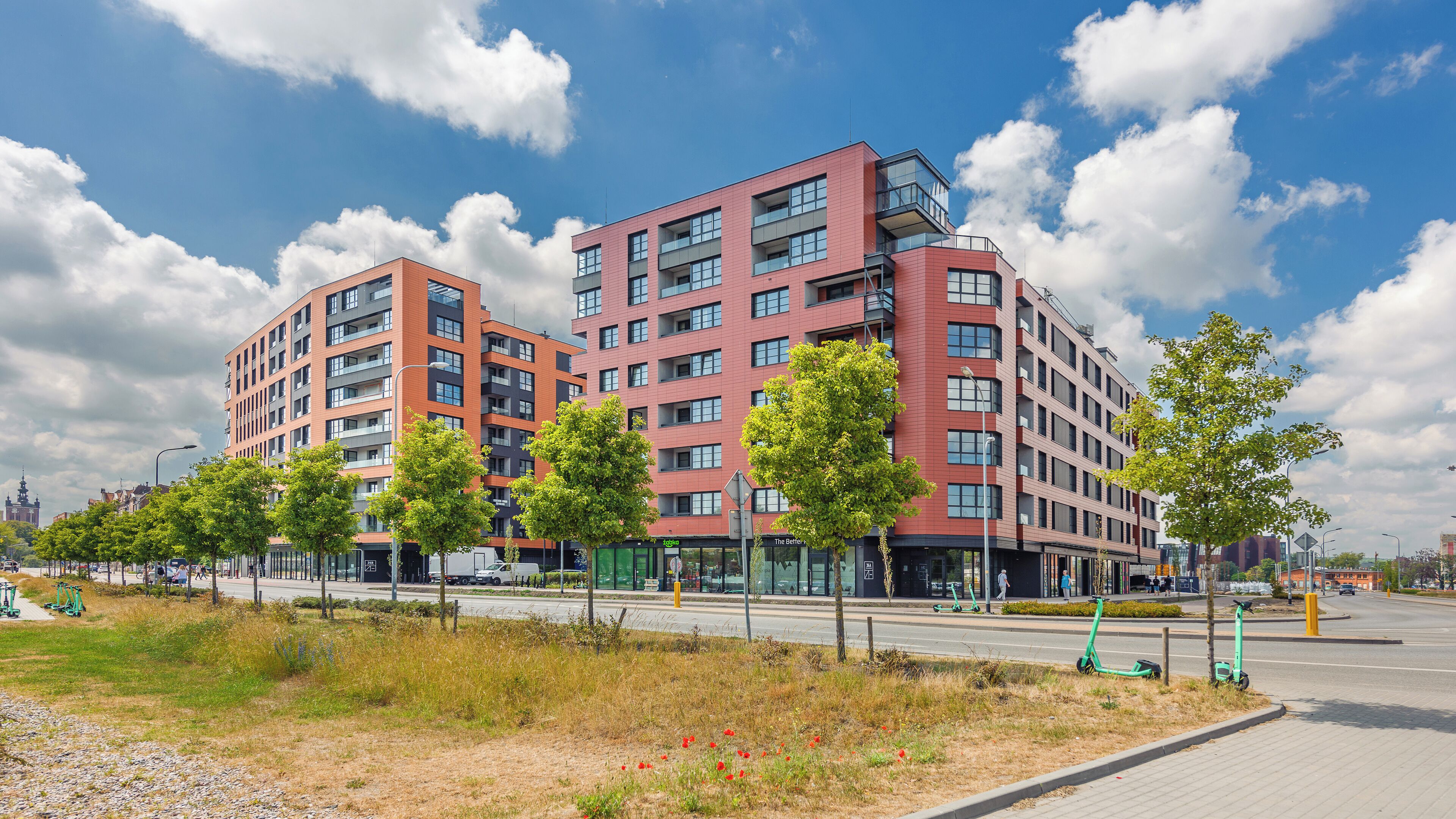 Een modern, meerlaags gebouw met een rode gevel en grote ramen.