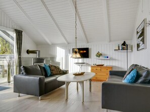 Ein modernes Wohnzimmer mit einer Couch, einem Couchtisch und einem Fernseher.