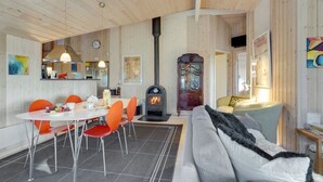 A cozy interior with a dining area, sofa, and a fireplace.