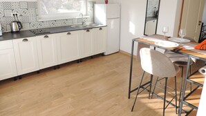 A modern kitchen with white cabinets, a stainless steel sink, and a window above the counter. - PREMONT STUDIOS GHIMBAV (Ghimbav)