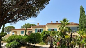 A two-story building with a tiled roof and a gravel driveway.