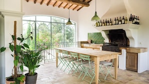 A spacious kitchen with a large dining table, a built-in stove, and a wine rack above the counter.