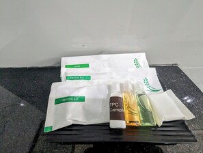 A dental kit, shaving kit, and two bottles of TPC Camphor on a black countertop. - TPC Camphor (Tiruchirappalli)