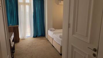 Een hotelkamer met een bed, een bureau en een raam met gordijnen.