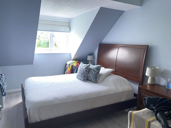 A bedroom with a bed, a nightstand, a lamp, and a window. - Comfortable family home adjacent to Millfield School and near Clarks Village (Street)