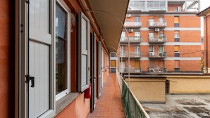 A narrow corridor with a brick wall on one side and a balcony on the other. - Studio Calari alle Mura by Wonderful Italy (Bologna)