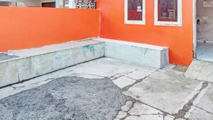 A courtyard with a stone floor and a low concrete bench. - Hotel O Luqman Kostel Syariah (Semarang)
