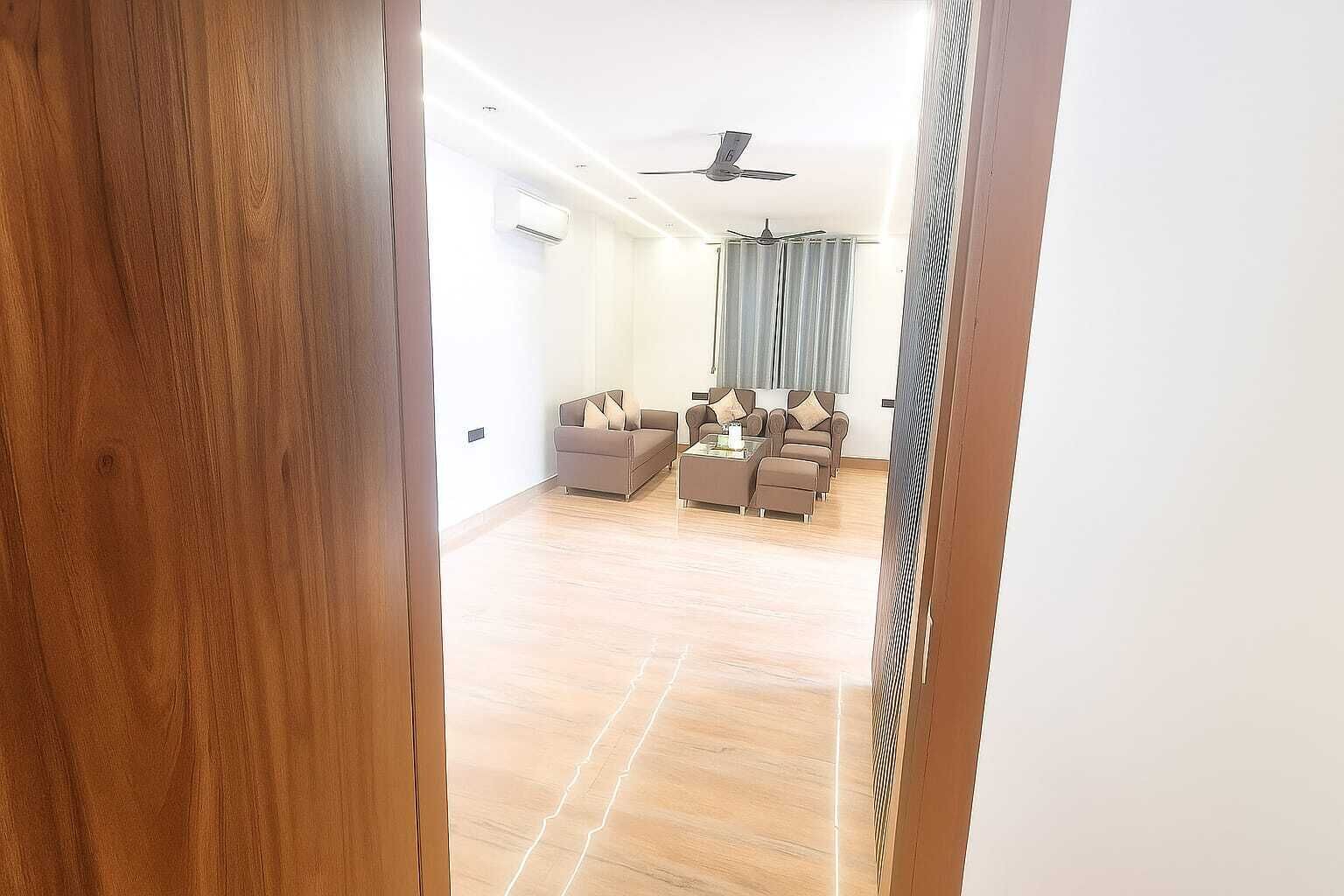 Un salon moderne comprenant un ensemble de canapés, une table basse et un ventilateur de plafond.