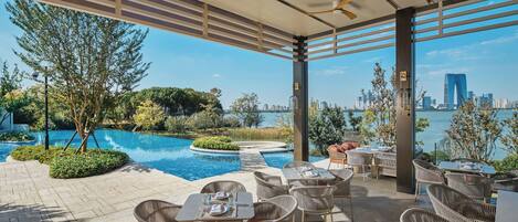 Una terraza en la azotea con mobiliario exterior, piscina y vistas del horizonte urbano.