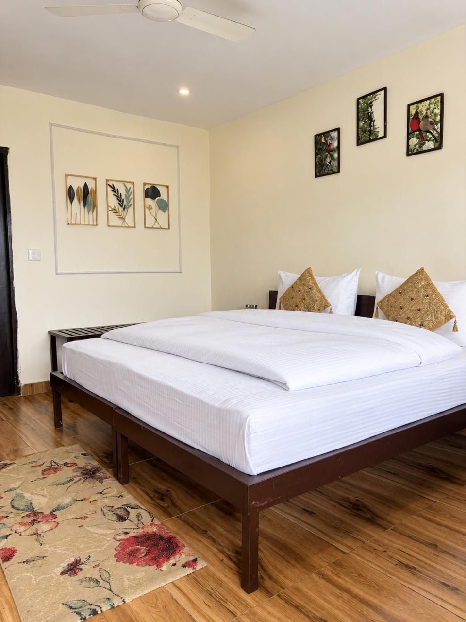 A bedroom with a wooden bed, a ceiling fan, and a floral rug.