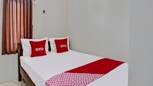 A neatly made bed with two pillows, a white bedspread, and a red blanket. - OYO 92541 Suny Kost Syariah (Sidoarjo)