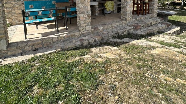 A stone building with a tiled bench and a table, featuring an archway entrance and outdoor seating area. - Masia CAN Tronc Casa Rural Tranquila,disfrutar en la Naturaleza en Familia (BARCELONA)