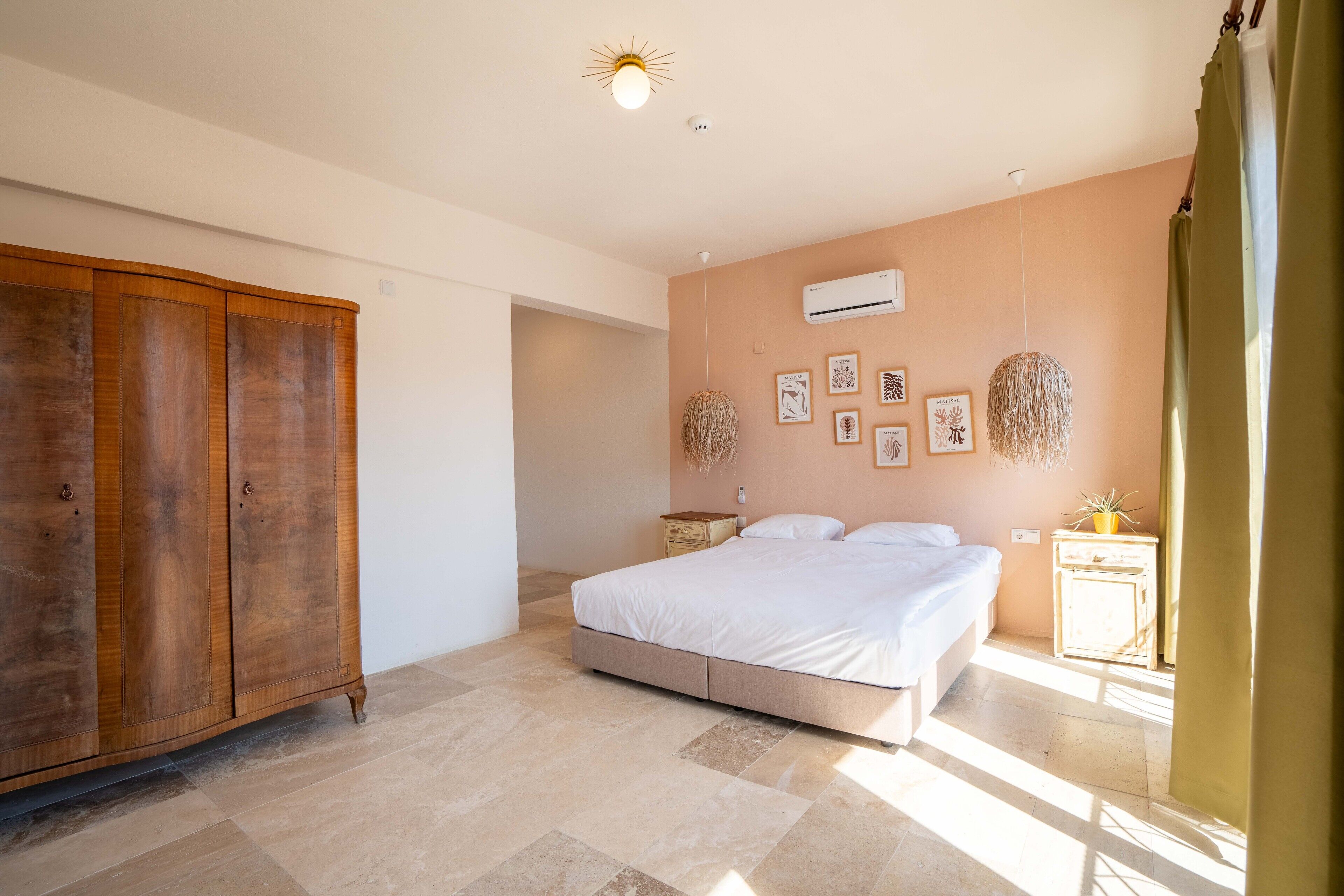 Un dormitorio con cama, armario y aire acondicionado instalado en la pared.