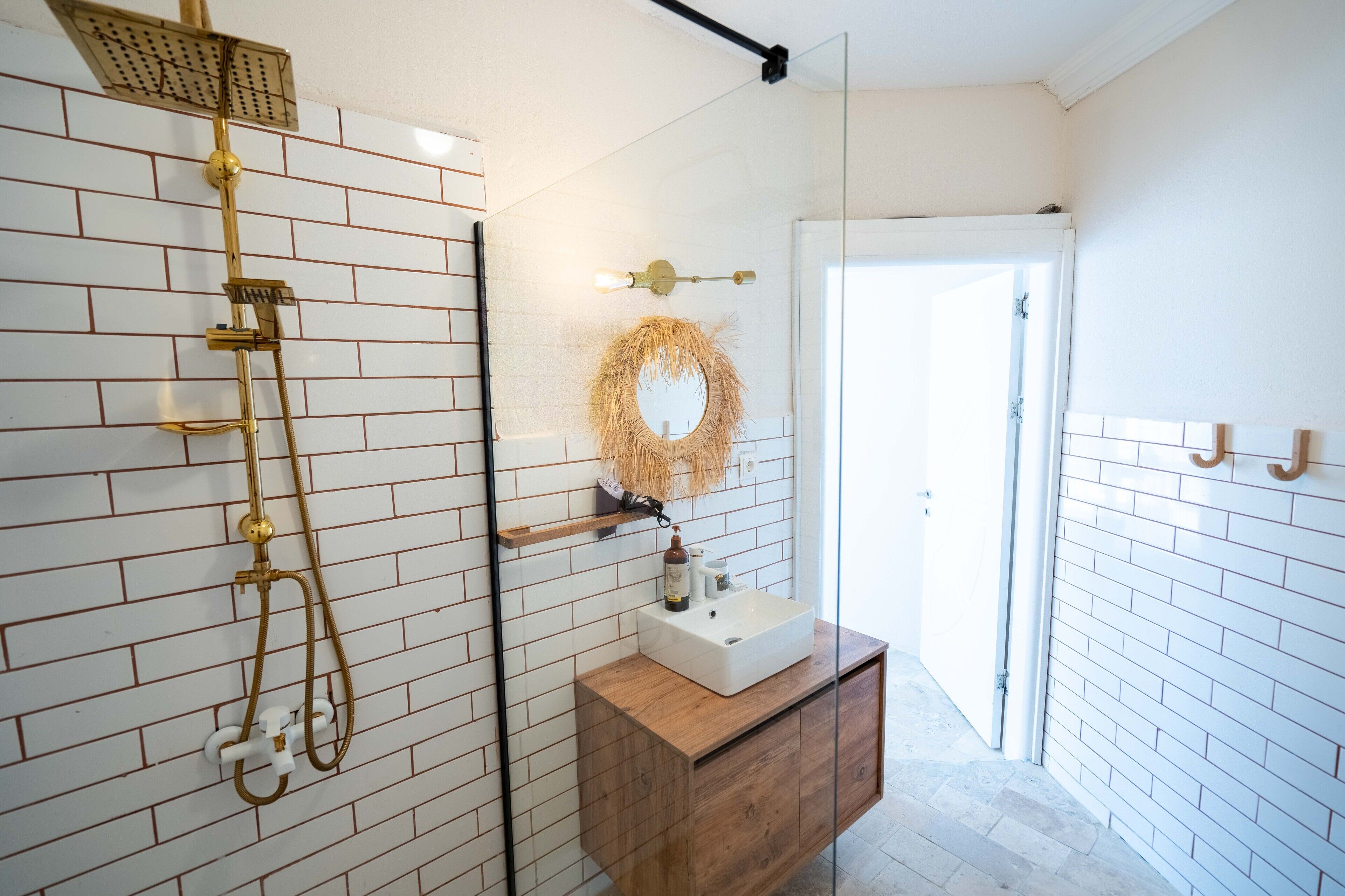 A bathroom with a shower, a sink, and a mirror.