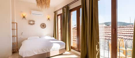 Un dormitorio con cama, ventanas amplias y vistas al exterior.